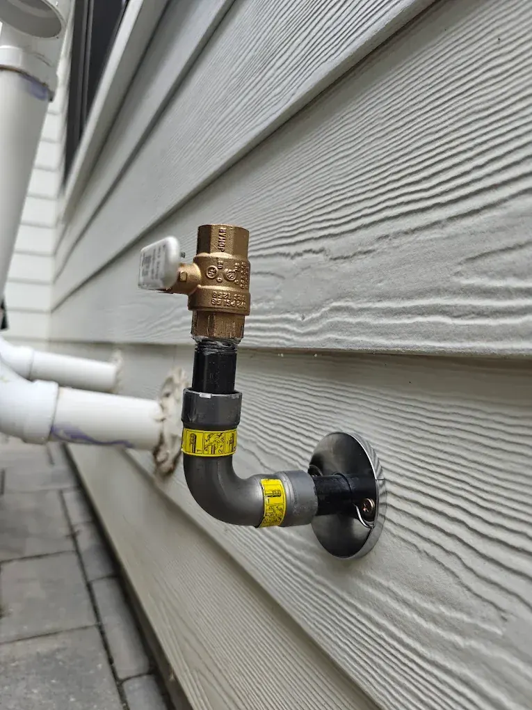Backflow prevention device and hose bib on the exterior wall of a Clifton, NJ building